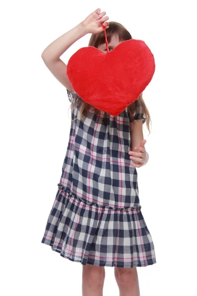 Linda niña en vestido a cuadros con corazón de juguete — Foto de Stock