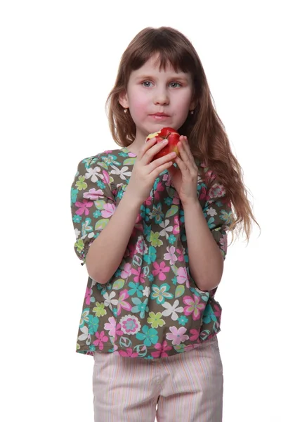 Kleines Mädchen in bunten Kleidern isst einen Apfel — Stockfoto