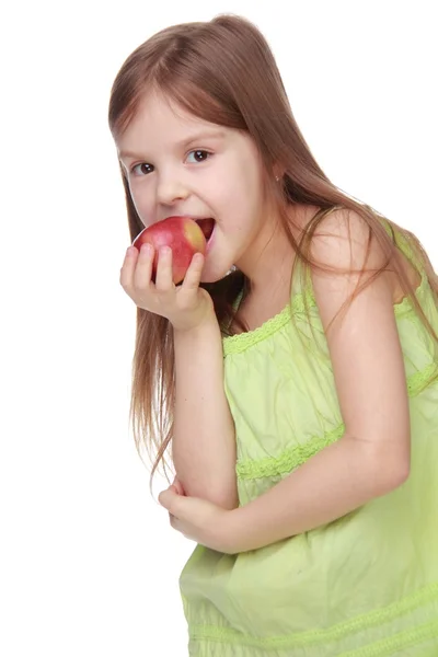 Pretty cheerful girl eats an apple Royalty Free Stock Images