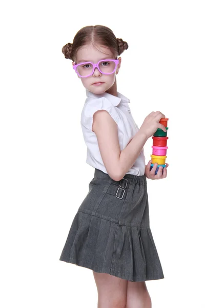 Studio image školačka s brýlemi pózuje s barvami — Stock fotografie