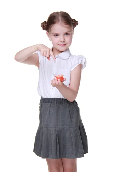 Студійне зображення школярки, яка позує помаранчевою фарбою — стокове фото