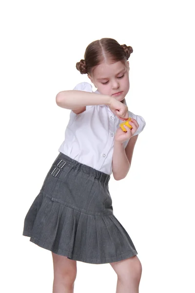 Lovely schoolgirl posing with finger painted in yellow — Stock Photo, Image