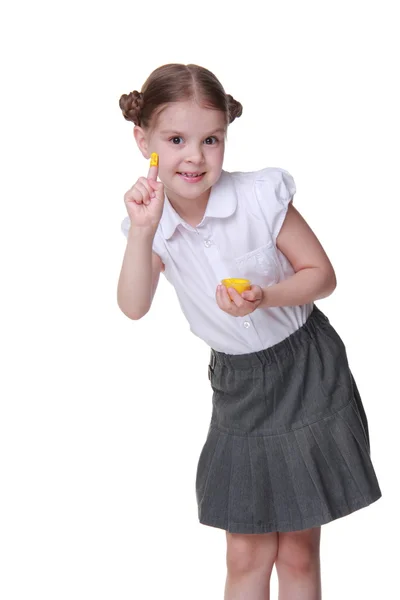 Belle écolière posant avec un doigt peint en jaune — Photo