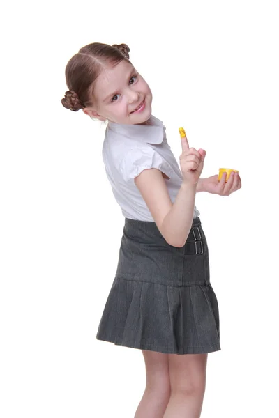 Lovely schoolgirl posing with finger painted in yellow — Stock Photo, Image