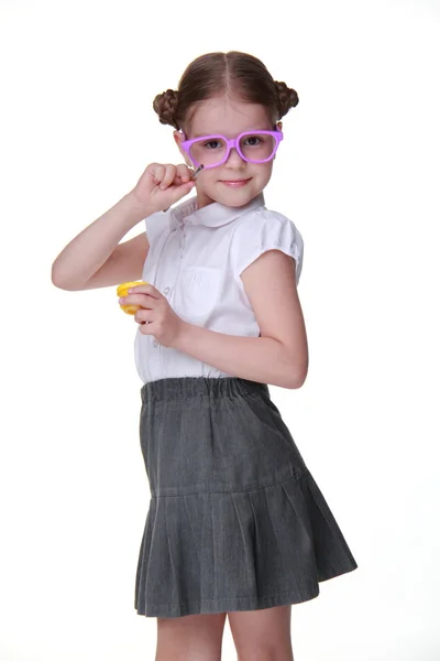 Studio image of schoolgirl with funny glasses posing with yellow paint and brush — Stock Photo, Image