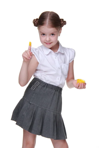 Lovely schoolgirl posing with yellow finger paint — Stock Photo, Image