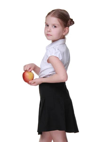 Retrato de una hermosa colegiala sosteniendo una manzana — Foto de Stock