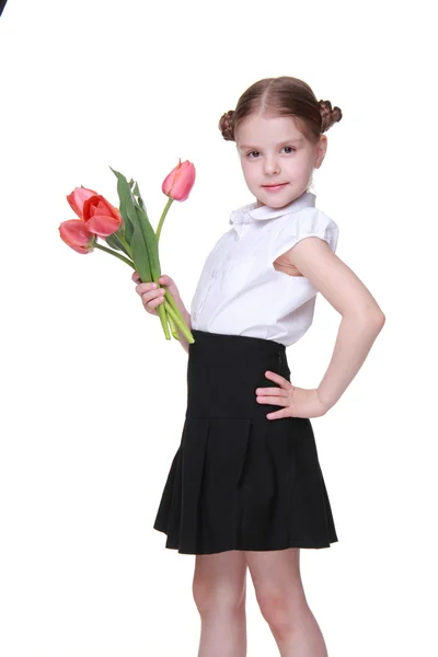 Nettes Schulmädchen mit einem Strauß Tulpen — Stockfoto