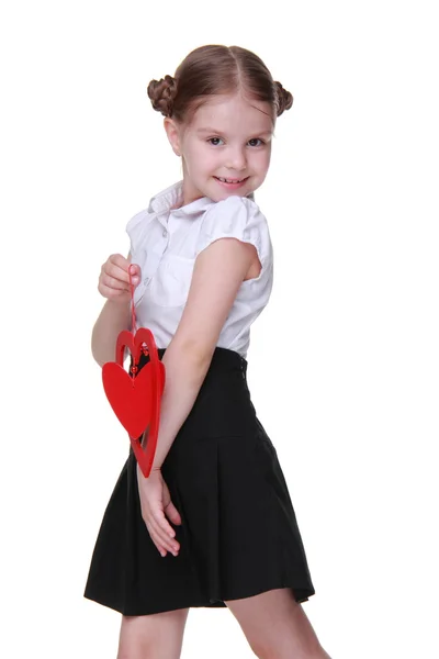 Caucasian lovely schoolgirl holding red heart symbol — Stock Photo, Image