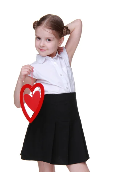 Caucasian lovely schoolgirl holding red heart symbol — Stock Photo, Image