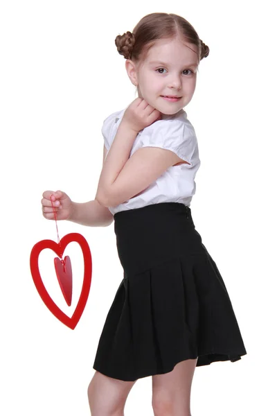 Caucasian lovely schoolgirl holding red heart symbol — Stock Photo, Image