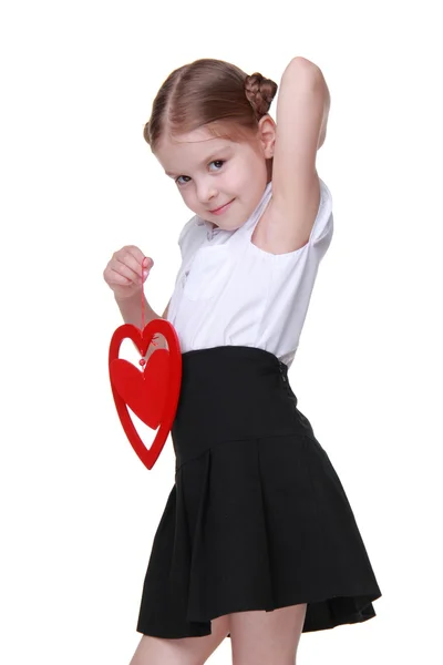 Caucásica hermosa colegiala sosteniendo el símbolo del corazón rojo — Foto de Stock