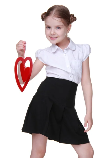 Caucasian lovely schoolgirl holding red heart symbol — Stock Photo, Image