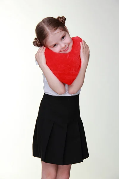 Caucasian schoolgirl with red heart symbol — Stock Photo, Image