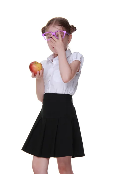 Porträtt av en skolflicka i glas håller ett äpple — Stockfoto