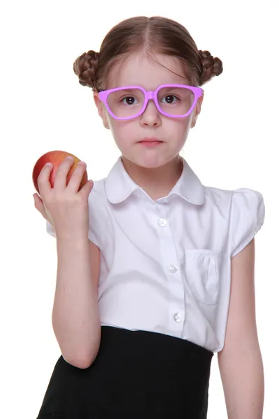 Porträtt av en skolflicka i glasögon äta äpple — Stockfoto