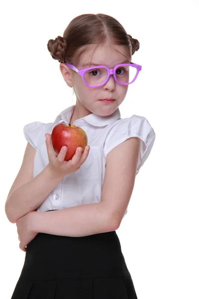 Retrato de una colegiala en gafas comiendo manzana — Foto de Stock