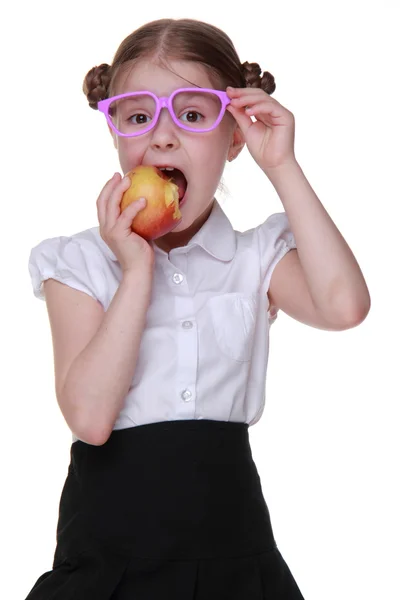 Portrait of a schoolgirl in glasses eating apple — Stock Photo, Image