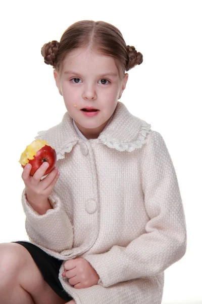 Retrato de estúdio de uma menina comendo uma maçã — Fotografia de Stock