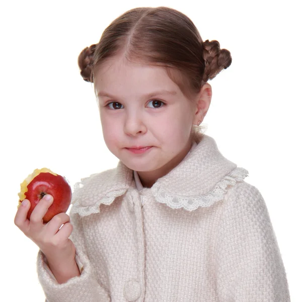 Studioporträt eines kleinen Mädchens, das einen Apfel isst — Stockfoto