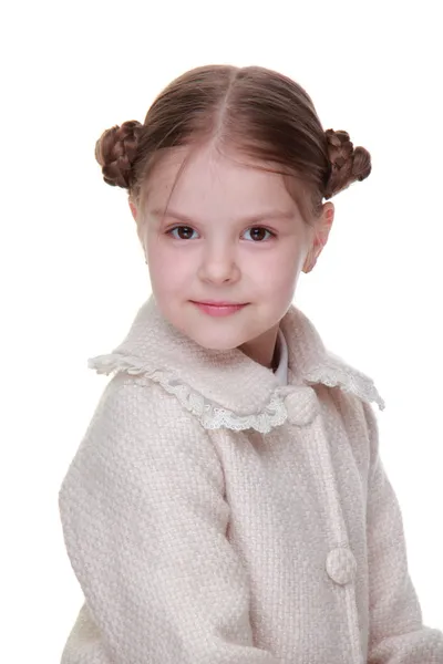 Studio portrait of a happy girl in a light coat — Stock Photo, Image