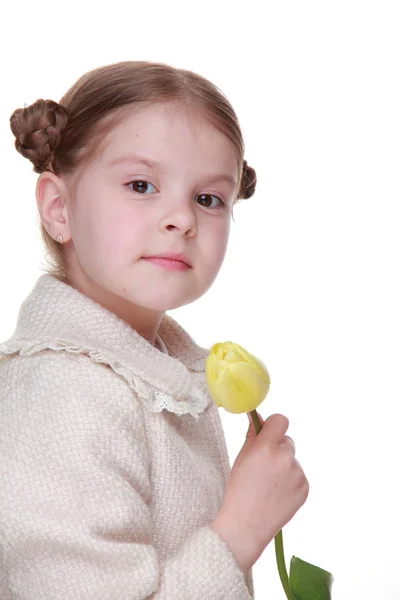 Studio portrait of a little girl with a yellow tulip — Stock Photo, Image