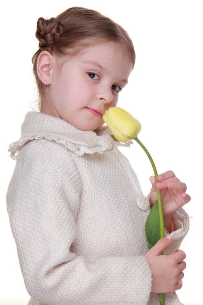 Studio portret van een klein meisje met een gele tulp — Stockfoto