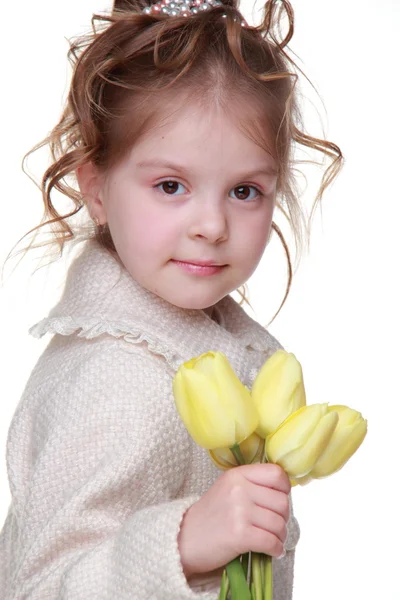 Красивая маленькая девочка в пальто держит букет тюльпанов — стоковое фото