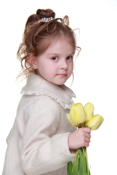 Schönes kleines Mädchen im Mantel mit einem Strauß Tulpen — Stockfoto