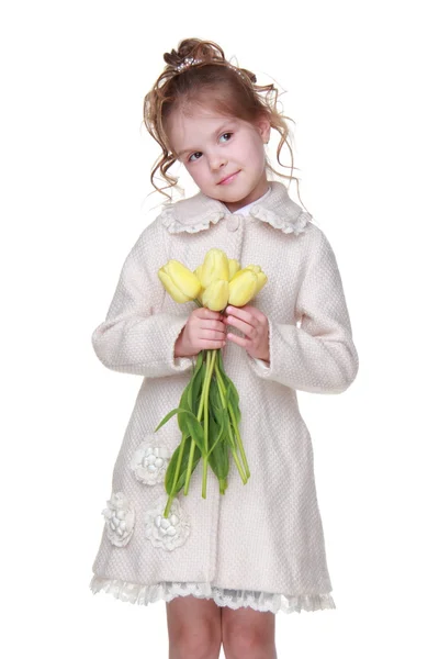 Bella bambina in un cappotto con un mazzo di tulipani — Foto Stock