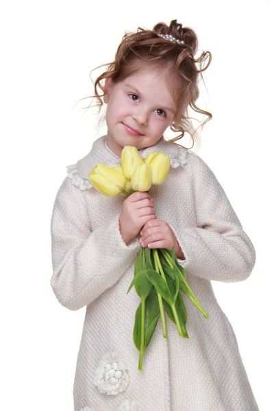 Mooi meisje in een vacht met een boeket van tulpen — Stockfoto