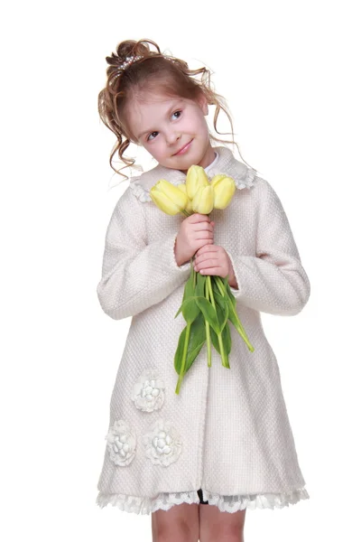 Krásná holčička v plášti drží kytici tulipánů — Stock fotografie