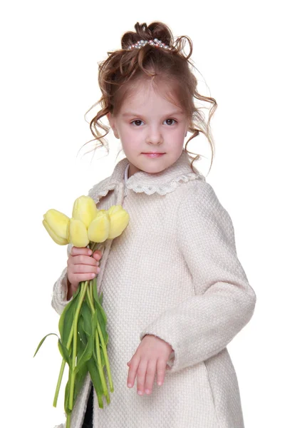 Mooi meisje in een vacht met een boeket van tulpen — Stockfoto