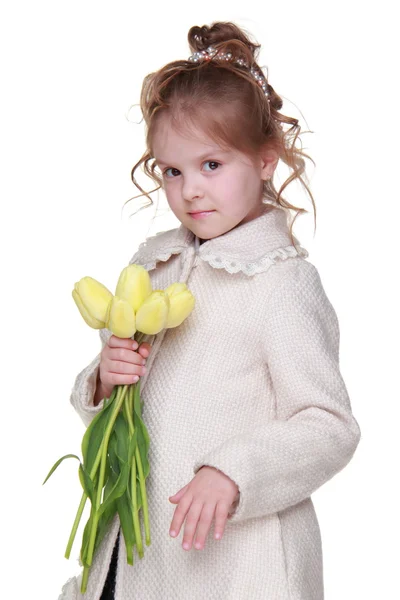 Krásná holčička v plášti drží kytici tulipánů — Stock fotografie