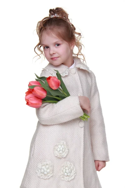 チューリップの花束を保持しているコートでかわいい女の子 — ストック写真