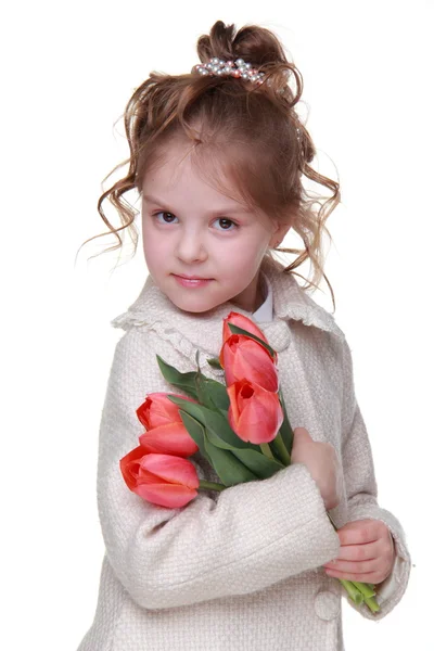 Schattig klein meisje in een vacht met een boeket van tulpen — Stockfoto