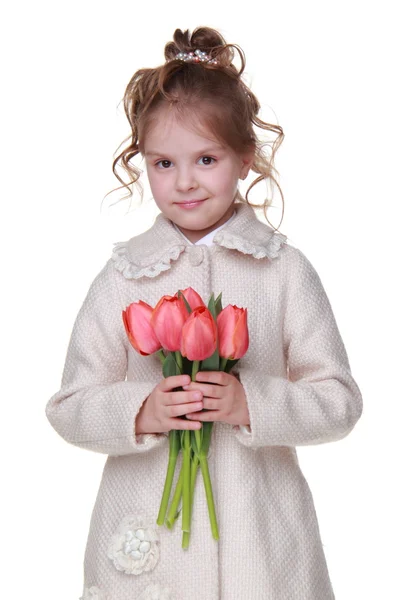 Gadis kecil yang lucu dalam mantel memegang karangan bunga tulip — Stok Foto