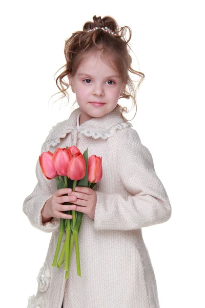 Linda niña en un abrigo sosteniendo un ramo de tulipanes —  Fotos de Stock