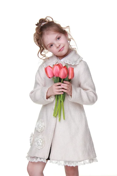 Roztomilá holčička v plášti drží kytici tulipánů — Stock fotografie