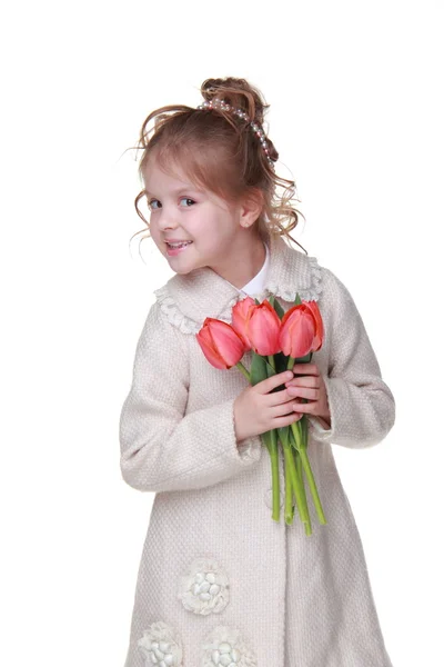 Schattig klein meisje in een vacht met een boeket van tulpen — Stockfoto