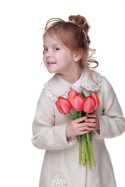 Roztomilá holčička v plášti drží kytici tulipánů — Stock fotografie