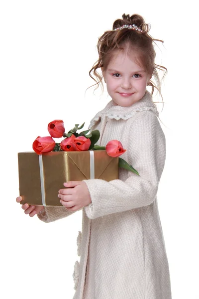 Roztomilá holčička v plášti drží kytici tulipánů a dárkový box — Stock fotografie