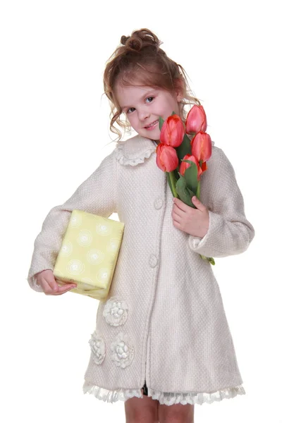 Mutlu küçük kız Lale ve hediye kutusu bir buket tutan bir ceket — Stok fotoğraf