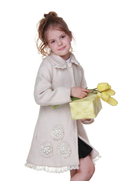Милая маленькая девочка с букетом тюльпанов и подарочной коробкой — стоковое фото