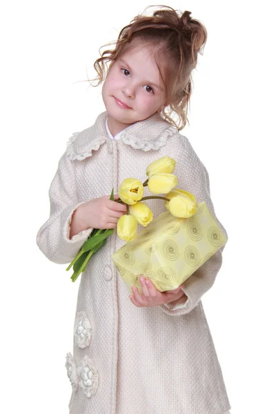 Linda niña sosteniendo un ramo de tulipanes y una caja de regalo — Foto de Stock