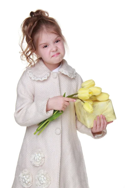 Niedliches kleines Mädchen mit einem Strauß Tulpen und einer Geschenkschachtel — Stockfoto