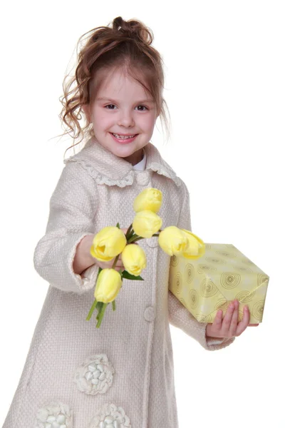 Милая маленькая девочка с букетом тюльпанов и подарочной коробкой — стоковое фото