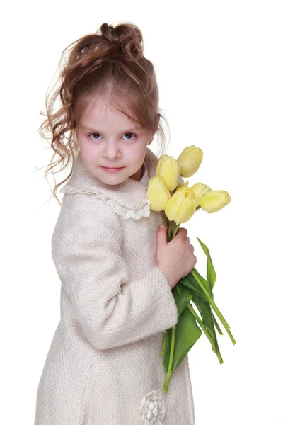 Petite fille mignonne dans un manteau tenant un bouquet de tulipes — Photo