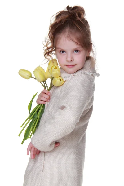 Χαριτωμένο μικρό κορίτσι σε ένα παλτό κρατώντας ένα μπουκέτο με τουλίπες — Φωτογραφία Αρχείου