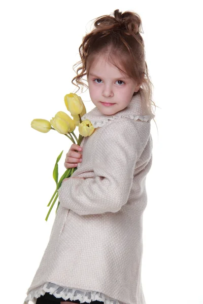 チューリップの花束を保持しているコートでかわいい女の子 — ストック写真